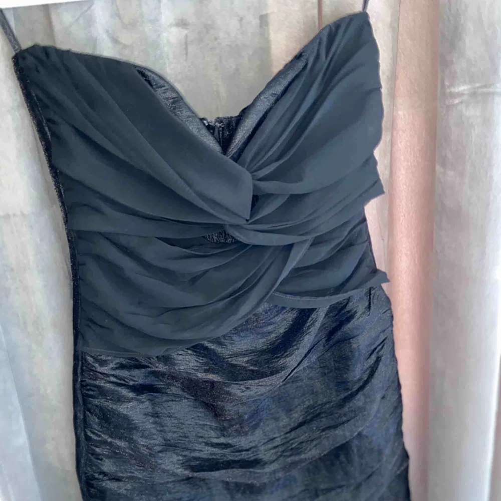 En svart klänning med lite volanger och dragkedja i ryggen. Jag köpte den i vintras och den är använd en gång och fortfarande i bra skick. Nypris- 399kr . Klänningar.