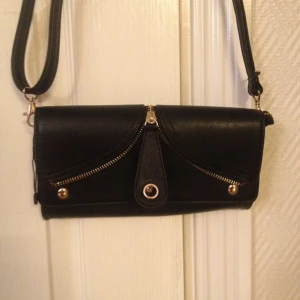 Svart Kuverväska/axelremsväska med guldiga detaljer, helt ny!  - Svart Kuverväska/axelremsväska med guldiga detaljer, helt ny! 