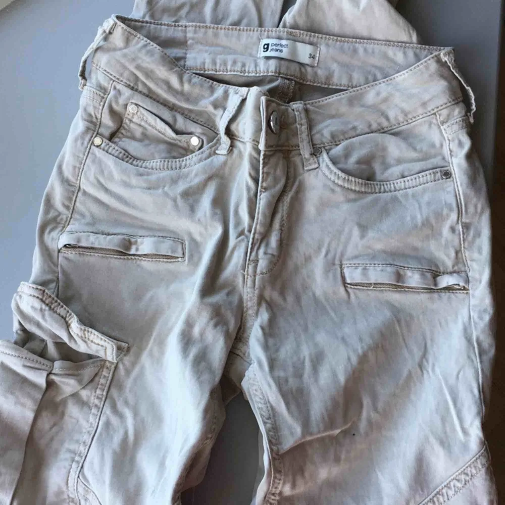 Ett par lågmidjade beigha  jeans med ficka på ena låret. ifrån Gina tricot. Oanvända. Köpta för 499kr med säljer för 120kr. Pris kan diskuteras!. Jeans & Byxor.