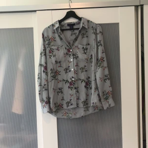  - Jättefin blus från Oasis med blommor och fåglar på. Färgen är lite grå/blå. Knappt använd men behövs strykas.