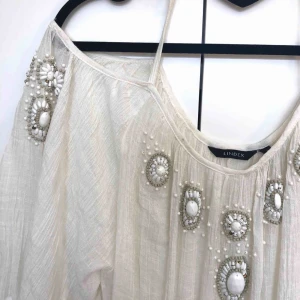  - En fin blus med pärlor, storlek s. Köparen betalar frakt 