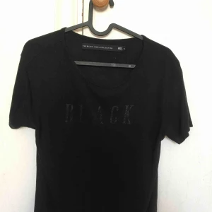  - T shirt där det står ”black” på, kommer ej igår vart den är ifrån men kan vara lager 157 då det står ”157”.  FRAKT INGÅR