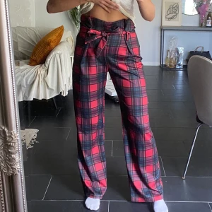 Rutiga byxor  - Rutiga byxor från Nelly med knytning i midjan. Frakt tillkommer.