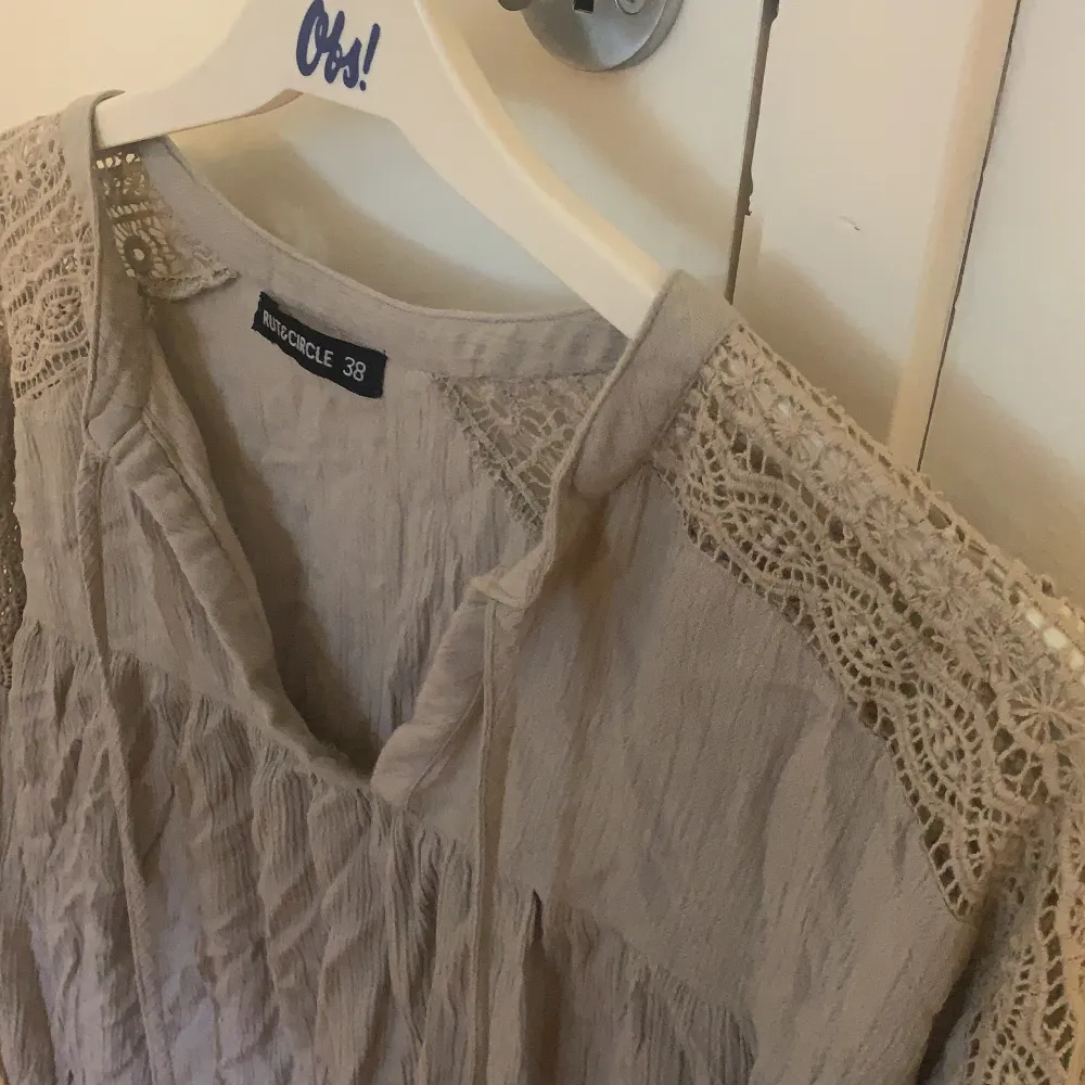 Säljer en beige/grå blus ifrån Ruth and circle. Strl 38, 40kr. Fina spetsdetaljer över axlarna. Köparen står för frakt.. Blusar.