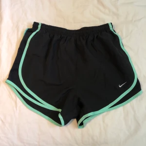Nike shorts med grön rand - Snygga Nike shorts med grön rand. Aldrig använda då jag har två andra par. Supersköna och högmidjade! Nypris: 349kr. 