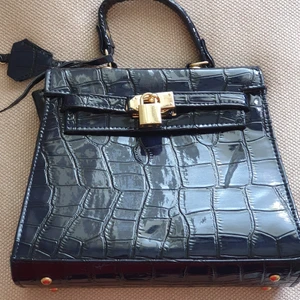 Marinblå handväska - Marinblå handväska (ej äkta läder/skinn) med röd insida. Aldrig använd! 