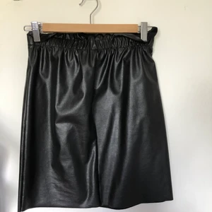 Svart skinkjil från Gina tricot strl Xs - Säljer min svart skinnkjol från Gina tricot i strl Xs kjolen är strechy så passar även till S