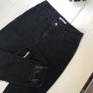 Svarta momjeans! - Ett par jättefina svarta ”momjeans” från NAKD. Använda en gång, därav riktigt bra skick. Slitningar längst ner (INTE egengjorda) som ger en fin look!! Storlek 38, men skulle mer säg 36-38💖 Nypris: 399kr