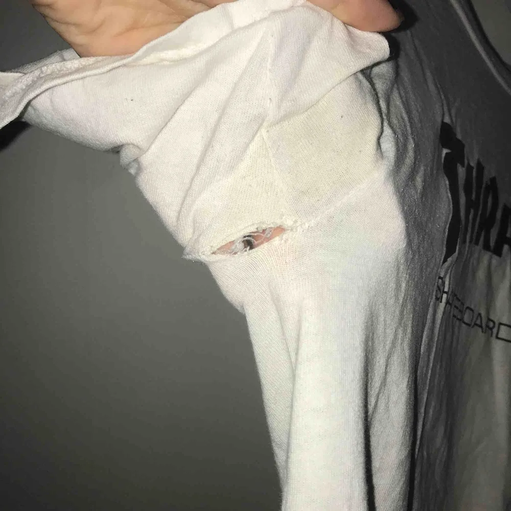 En vit Thrasher t-shirt med svart logga, OBS att den har ett hål i ena armhålan men som lätt kan lagas. Helst mötas i Göteborg men fraktning kan diskuteras 😊😊. T-shirts.