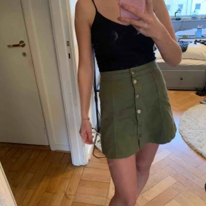  - Militärgrön kjol med knäppning framtill. Priset är exklusive frakt. 