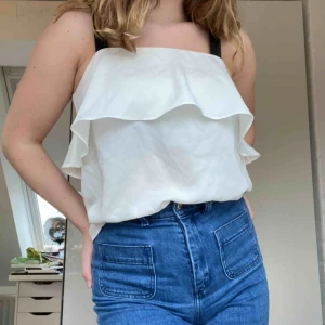  - Ett vitt linne med svarta axelband från HM. Skriv för mer info. Frakt tillkommer.