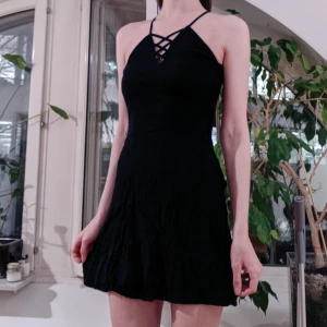  - Svart kort klänning, reglerbara band som korsas i ryggen!  Skönt mjukt tyg som faller fint. 