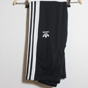 Adidas Trackpants Stl S - Trackpants från adidas originals. Knäppning på sidorna. Slim fit utan fickor. Storlek S. Använda en gång inomhus annars i otroligt fint skick! Frakt 65kr
