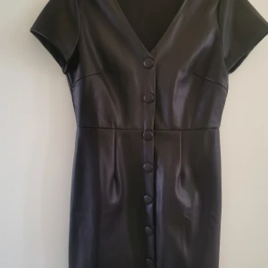 Klänning - Säljer denna klänning aldrig använd, syntetskinn