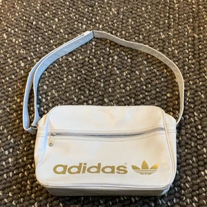 Adidasväska guldig och vit - En gammal väska från adidas. Ganska många år gammal och i helt ok skick. Använd en hel del. 💞