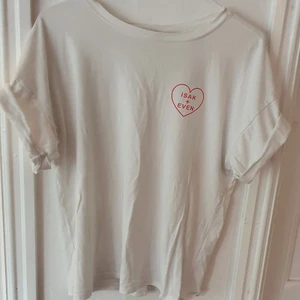 Vit SKAM t-shirt - Vit t-shirt med trycket "Isak+Even" i rött. Trycket är inspirerat av serien SKAM 🥰 Köpt på Gina Tricot för ca 3 år sen, men sparsamt använd så i bra skick. Storlek XS men oversized. Säljs då den ej används. Kontakta vid frågor/intresse 💜 frakt inräknad