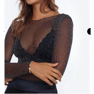 Transparant glittrig tröja - Säljer en svart transparant tröja med silver glitter i. Den har som små volanger längst ut på ärmarna, vid halsen och längst ner på tröjan. Den är endast använd en gång. Frakt tillkommer:) (den är väldigt stretchig så funkar som S/M)