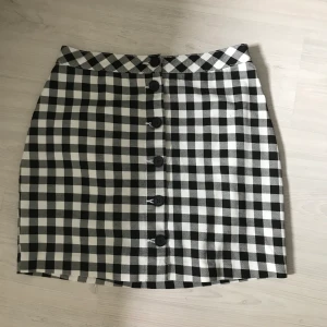 Kjol ifrån H&M - Rutig kjol ifrån H&M med svarta knappar som går att knäppa upp.  Köparen står för frakt. Skickas inom 1-2 dagar.