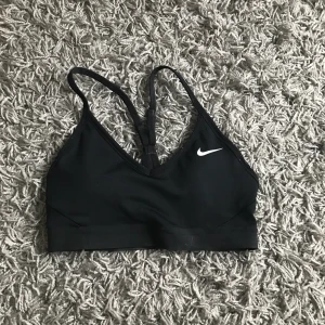 Sport-bh från nike  - jättefin sport-bh från nike! säljer då den är förliten för mig. använd fåtal gånger och är i fint skicka 💕 köparen betalar för frakt! kan tänka mig gå ner i pris vid snabb affär!