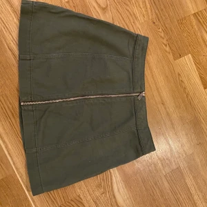 Grön kjol 38 - Grön kjol med dragkedja hela vägen. Storlek 38