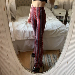 Mönstrade utsvängda byxor  - Mönstrade utsvängda byxor från H&M. Färgen är rödare i verkligheten ❤️. Lite smutsiga längst ner men det syns inte tack vare mönstret. Längden passar bäst om man är över 165cm