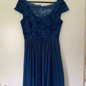 Blå klänning - Klänning köpt från Vila. Djup i ryggen. Använd en gång. Storlek S.