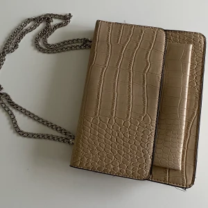 NELLY.COM axelväska  - Skit snygg fake ormskinn väska i beige från Nelly.com😍💞🖤 mycket utrymme inuti , du får plats med allt du behöver inuti, använd några gånger men ser inte sliten ut💞😍