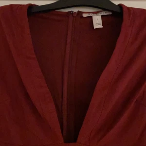 Röd klänning - Knappt använd, mörkröd klänning med lång urringning.