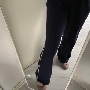 Byxor från BikBok - Marinblåa byxor från BikBok med en rad på benen. Byxorna är jätte sköna och sitter bra i rumpan men är tyvärr för långa för mig som är 163 cm lång, byxorna är använda en gång och har resår i midjan. De är i storlek S. 