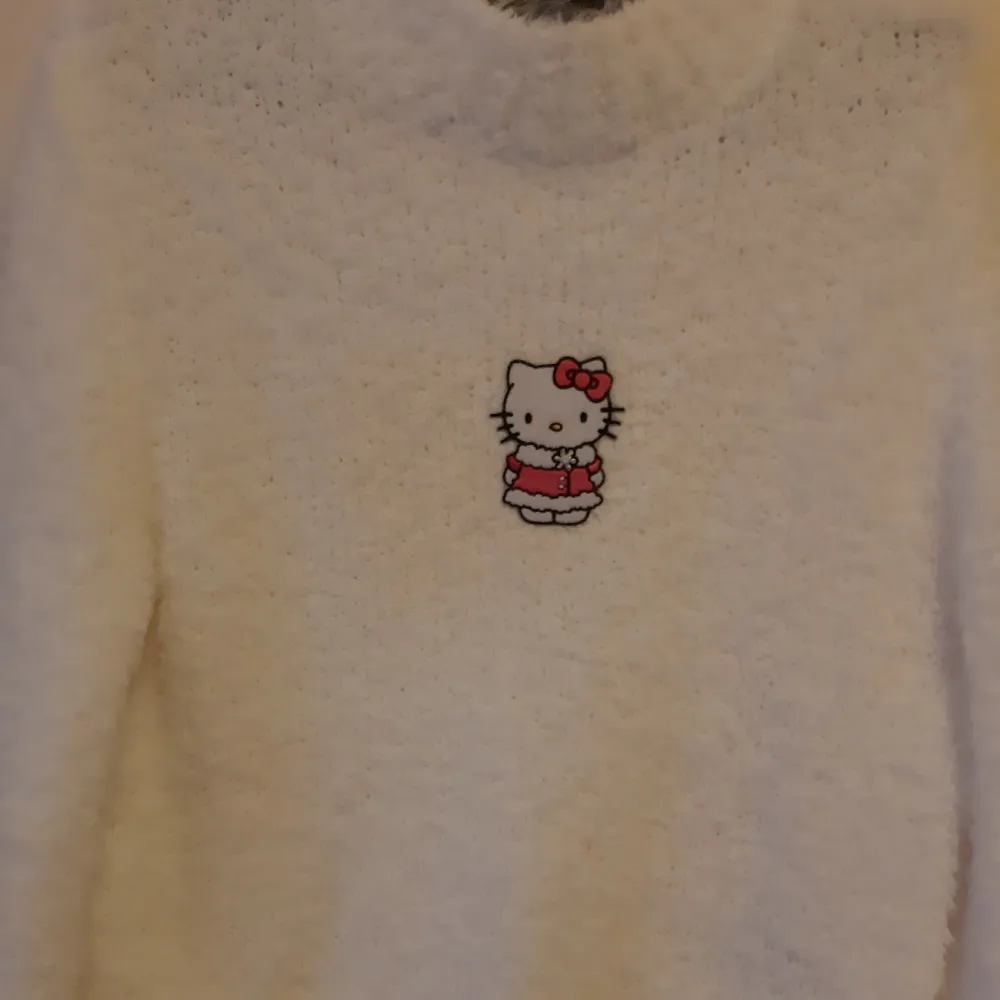 Vit fluffig tröja med en patch mitt på av Hello Kitty i vinterjacka. Den har lite missfärgning på ena sidan av hello kitty från att stryckjärnet var lite för varmt. Det är inte jättetydligt men det syns lite på bild 2. Budgivning, DM/kommentera! Högsta bud: 350 (exkl frakt). Stickat.