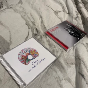 Queen cd skivor - Två av queens skivor, lite repiga på utsidan men inget så speciellt. Själva skivorna är hela. 