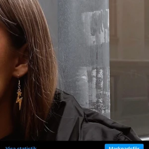 Örhängen, smycken  - I03. Jättefina öronhängen med blixtrar och stjärnor i guld. Glöm inte att 10% av vinsten går oavkortat till organisationen kvinna till kvinna