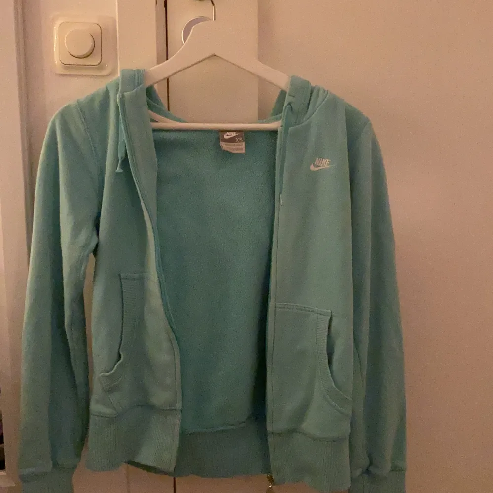 Jag säljer denna blåa Nike zipper hoodie eftersom den inte kommer till användning längre men den är i nästan nyskick, den är ÄKTA. Den är lite oversized och lång så passar mellan storlekarna xs-m. Om någon har några andra frågor hör bara av er!💞💞💞. Hoodies.