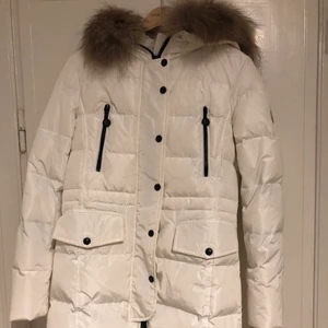 Moncler lång jacka  - Vit lång riktig Moncler jacka med äkta päls runt kragen. Använd en eller två gånger. Storlekarna är lite speciella men den passar mig som är en S och 172cm lång.