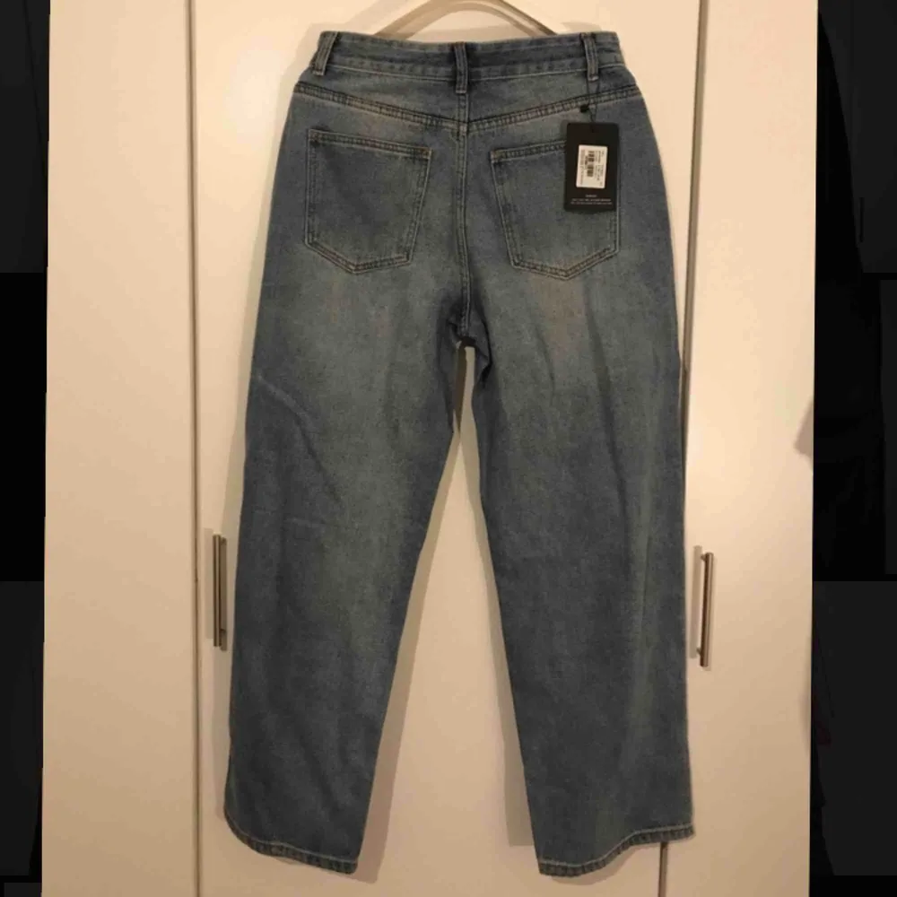 Blåa boyfriend jeans med hål från prettylittlething ”Mid Wash Baggy Low Rise Distressed” Säljer dessa snygga jeans på grund av att de är för stora för mig, etiketten sitter kvar och de är aldrig använda. Jeans & Byxor.