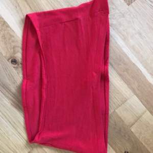 Röd bandeau topp med lite längre tyg där fram❤️ Aldrig använd och köpt förra sommaren. Den sitter precis på brösten. Frakt 42kr 💞