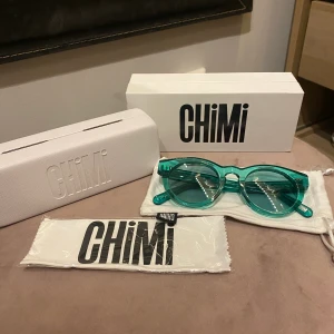 Chimi Eyewear  - Solglasögon från populära märket Chimi eyewear. Har legat i fodralet sen jag köpte de i somras och är endast provade. De är i modellen #003 o färgen Aqua med transparent lins, superfin färg.  Nypris: 999kr  Mitt pris: 450kr Allt på bilden ingår de vill säga kartong, hårt fodral, dust bag och oanvänd putsduk.