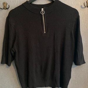 . - Svart ribbad tröja med dragkedja, står ingen storlek i men kan gissa på M/L, ska va en kortare modell. 