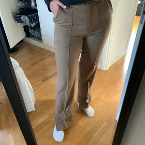 Kostymbyxor - Beiga kostymbyxor med pressveck och slit. Använda max 4 gånger, så de är i mycket bra skick. Köpta för 499kr.