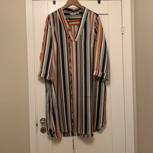 Randig klänning - Randig klänning i glansigt skönt material.