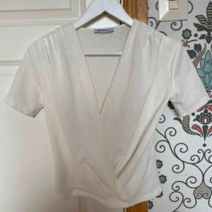  - Vit topp, med en twist vid magen. Helt oanvänd!