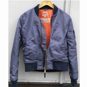  - Vintage bomberjacka i blå med coolt organget innetyg från SCHOTT. Använd ganska mycket, men inga synliga repor förutom att jag sytt ihop ”hängflärpen” (se bild 3). Storlek M man ganska liten i storleken. Pris går att diskutera! Nypris: 1900kr. 💜💜