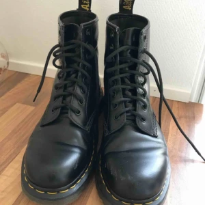  - Ett par klassiska svarta docs. Använd fåtal gånger, så fin sula. Tyvärr har de fått sig lite revor på tårna och några veck i skinnet. Annars väldigt fina. Strl 39.   Kan hämtas upp, eller så tillkommer frakt. 