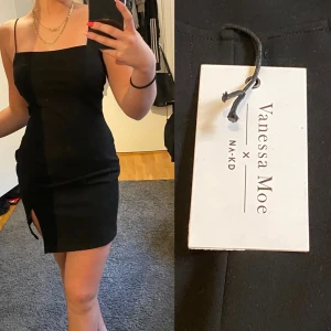 NA-KD tajt klänning , Billigt! - Medium/Small  svart tajt klänning  med sytt med lite öppet vid benet.  Från NA-KD Oanvänd 