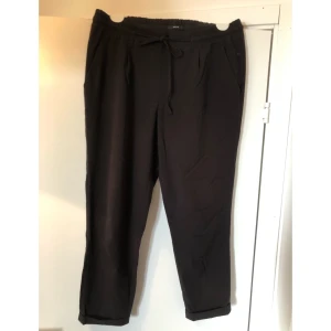 Svarta kostymbyxor - Svarta ankellånga kostymbyxor med resår och knytband i midjan. Några cm för korta för mig som är 177cm. Fint skick! Köpta fr Zalando.