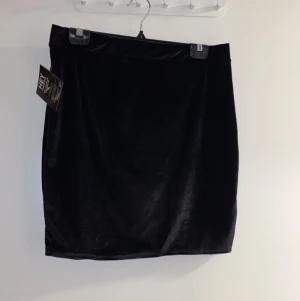 Sammetskjol, storlek L - Svart fin sammetskjol. Helt oanvänd, prislappen sitter kvar. 