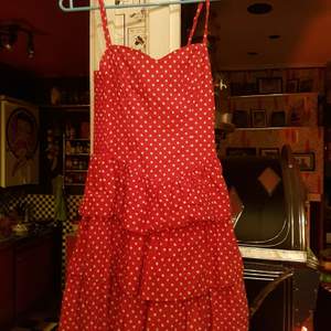 En klänning i fint skick röd med vita prickar 