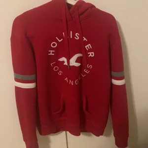 Röd hollister kofta  - Säljer nu denna hollister kofta då den inte längre kommer till användning. Den är i storlek xs men stor i storleken och passar däriför även S. Koftan är i väldigt bra skick. 