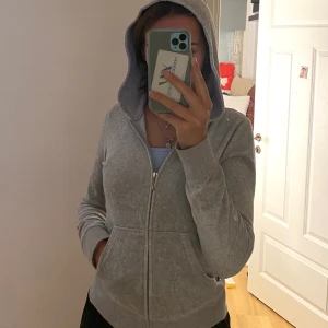 ÄKTA JUICY COUTURE KOFTA - S - ÄKTA Juicy Couture kofta i storlek S i färgen grå, ”mjukis” material. Endast koftan! På ryggen är det paljetter och det står Juicy Couture med guldiga paljetter. Använd få gånger. Köpt för 1999kr. Om fler är intresserade gäller högsta budet.