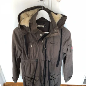  - Militärgrön jacka från bondelid. Fina dekorationer med blommor. Går att justera i midjan.  Storlek XS men jag upplever den som en S.  Den är i god skick, använts endast ett fåtal gånger. 